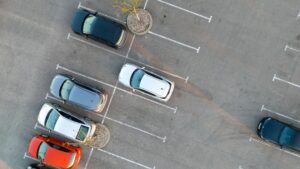 Vista aérea de un aparcamiento al aire libre con varios coches y muchas plazas libres